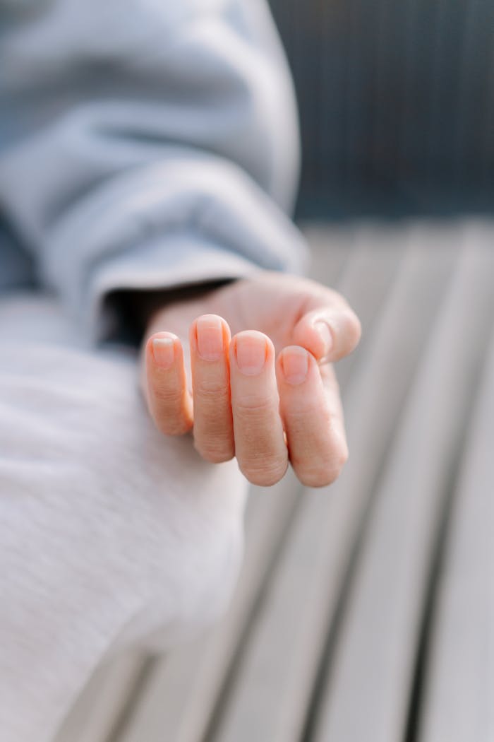 A close-up of an open hand resting on outdoor wooden planks, inviting tranquility.